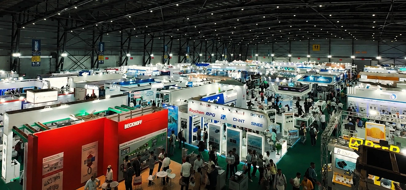 An exhibitor demonstrating a robotic arm to visiting engineers at an Automation Expo stall
